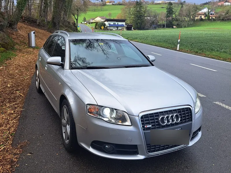 Break Audi A4 gris au bord d'une route de campagne